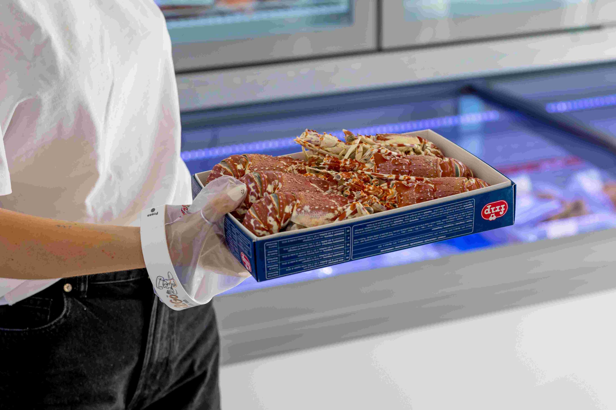 Glove2Go glove being used while serving seafood from a refrigerated counter.
